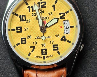 Reloj de pulsera vintage Seiko 5 con esfera amarilla, restaurado, con fecha y día de trabajo.