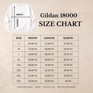 Może przedstawiać: Tabela rozmiar&oacute;w Gildan 18000 z grafiką białej bluzy oraz wskaźnikami szerokości i długości. Tabela zawiera rozmiary od S do 5XL wraz z odpowiednimi wymiarami w calach oraz szczeg&oacute;łami dotyczącymi składu materiału.
