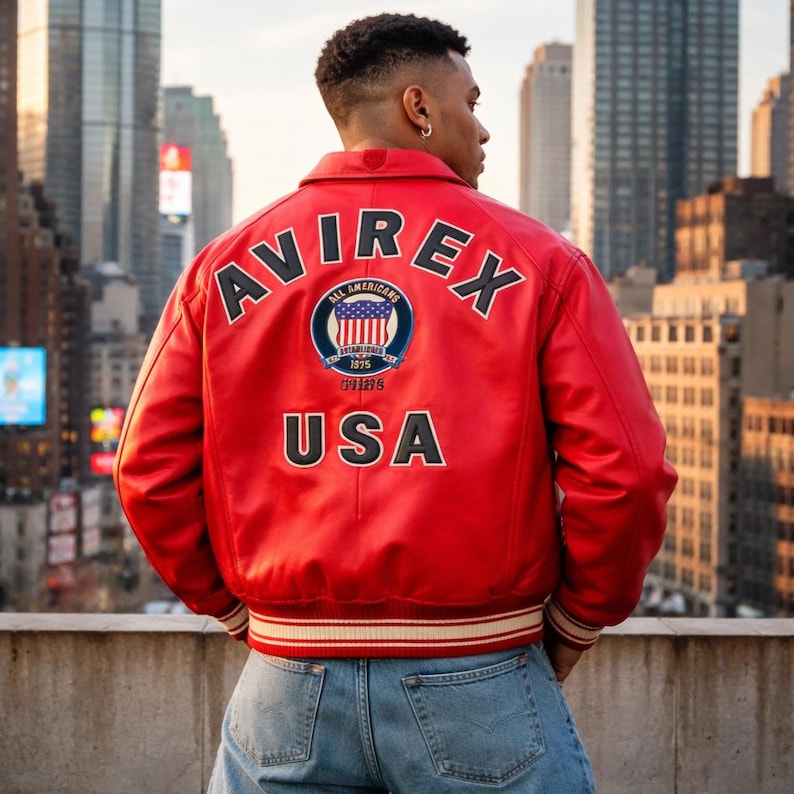 May include: A red leather jacket with the word "AVIREX" across the shoulders and "USA" at the bottom. The jacket features a circular patch with an American flag design and the words "ALL AMERICANS" and "ESTABLISHED 1975".