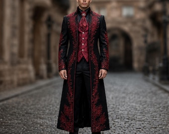 May include: A long black coat featuring intricate red embroidery along the lapels and front edges, worn over a matching red patterned vest with silver buttons, a black collared shirt, a red cravat with a central pin, and black trousers.