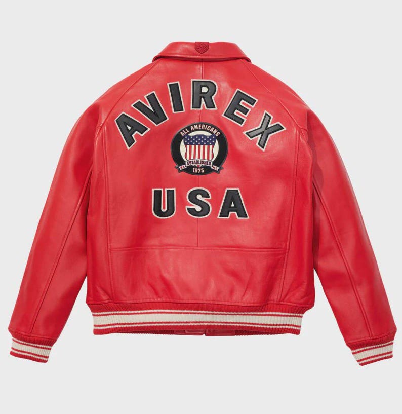 May include: Red leather jacket with the word "AVIREX" arched across the shoulders and "USA" below a circular patch with the American flag. The jacket has a ribbed collar, cuffs, and hem with white stripes. The jacket is a classic bomber style.