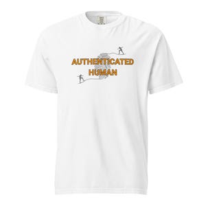 Op de afbeelding: Wit T-shirt met de tekst "AUTHENTICATED HUMAN" in oranje en zwart. Het ontwerp bevat een vingerafdruk en twee kleine figuren. Het shirt heeft een ronde hals.