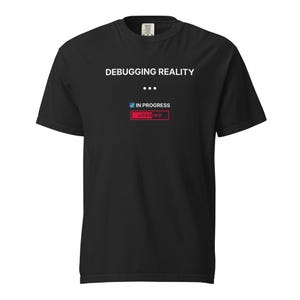 Peut inclure: T-shirt noir avec l'inscription "DEBUGGING REALITY" au-dessus d'une barre de chargement. La barre de chargement indique "IN PROGRESS" avec une coche et un bouton rouge "LOADING".