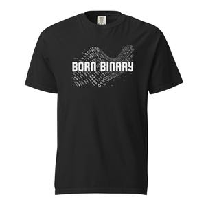 Puede incluir: Camiseta negra con el texto blanco "BORN BINARY" sobre un diseño ondulado de código binario. La camiseta es de cuello redondo y manga corta.