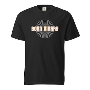 Peut inclure: T-shirt noir avec l'inscription "BORN BINARY" en lettres orange-jaune audacieuses, au-dessus d'un motif circulaire de code binaire. Le t-shirt est à col rond.