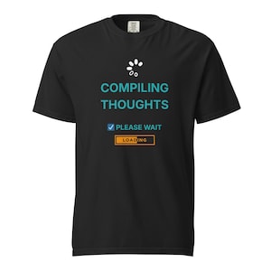 Peut inclure: T-shirt noir avec l'inscription "COMPILING THOUGHTS" en turquoise, un symbole de chargement et le texte "PLEASE WAIT" avec une coche. Le mot "LOADING" est dans un encadré orange. Un t-shirt graphique humoristique.