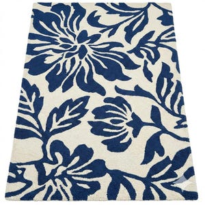 Puede incluir: Una alfombra rectangular con fondo crema y un dise&ntilde;o floral azul marino repetido. El patr&oacute;n presenta grandes flores y hojas estilizadas. La alfombra est&aacute; hecha de un material suave y afelpado, adecuado para una sala de estar o dormitorio. El dise&ntilde;o es moderno.