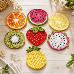 May include: A set of seven crocheted fruit coasters featuring an orange slice, watermelon slice, lemon slice, kiwi slice, strawberry, dragon fruit slice, and pineapple. Each coaster displays vibrant colors and detailed textures representing the fruit.