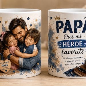 Puede incluir: Dos tazas de cerámica blanca con una foto de un padre abrazando a sus dos hijos. El diseño incluye detalles en azul y dorado, estrellas, un reloj de bolsillo y el texto PAPA Eres mi HEROE favorito junto a otras frases.
