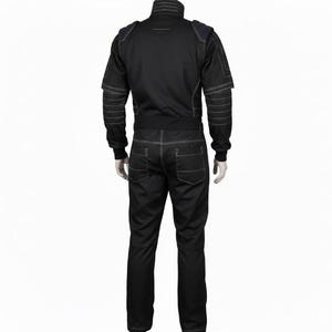 Op de afbeelding: Een zwarte jumpsuit met een hoge kraag, lange mouwen met geribbelde boorden en zichtbare witte contraststiksels. Het kledingstuk is voorzien van schouderpanelen, een getailleerde tailleband en twee achterzakken, weergegeven vanaf de achterkant.