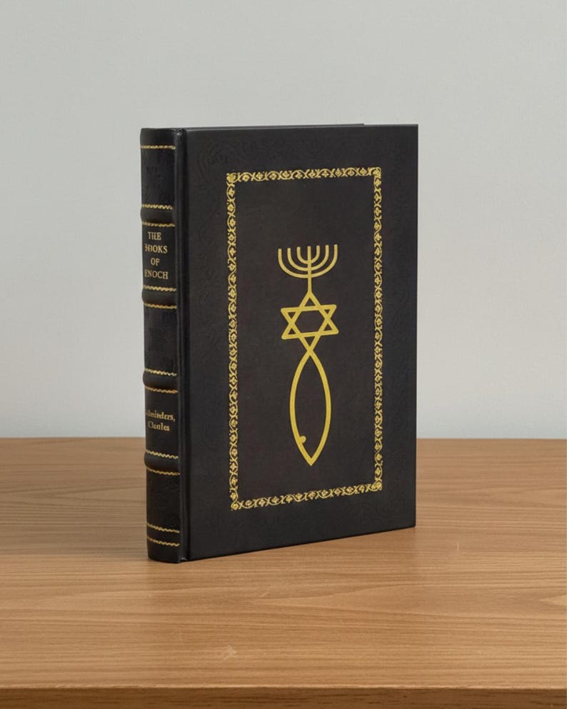 Puede incluir: Un libro de tapa dura negro titulado "The Books of Enoch" con detalles dorados. La portada presenta una estrella de David dorada, un menor&aacute; y un s&iacute;mbolo de pez dentro de un borde decorativo. El lomo muestra el t&iacute;tulo y el nombre del autor.