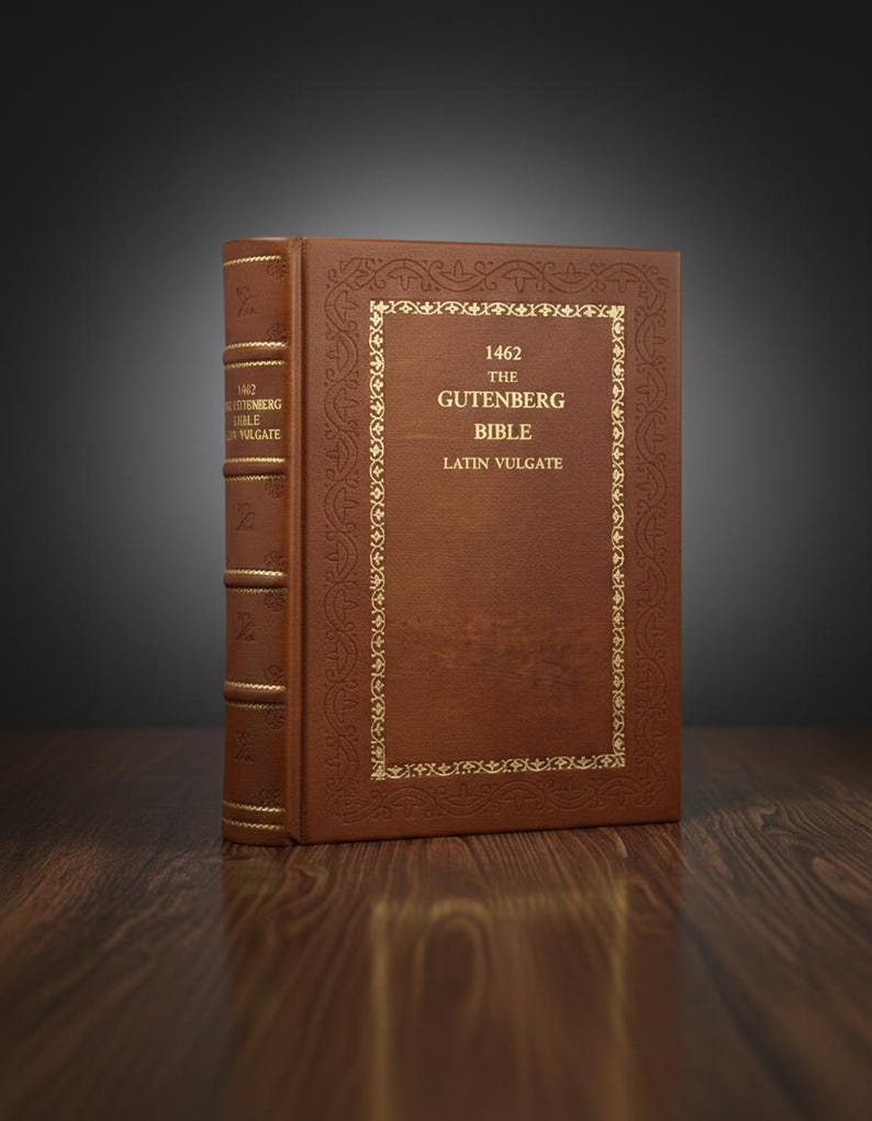 May include: A brown leather-bound book, the Gutenberg Bible, stands upright. The cover features gold lettering and decorative borders. The spine also has gold lettering. The book is on a wooden surface.