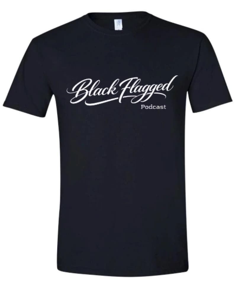 May include: A navy blue t-shirt with the words "Black Flagged" in a white, cursive font, with "Podcast" in a smaller font below. The shirt is a crew neck style.