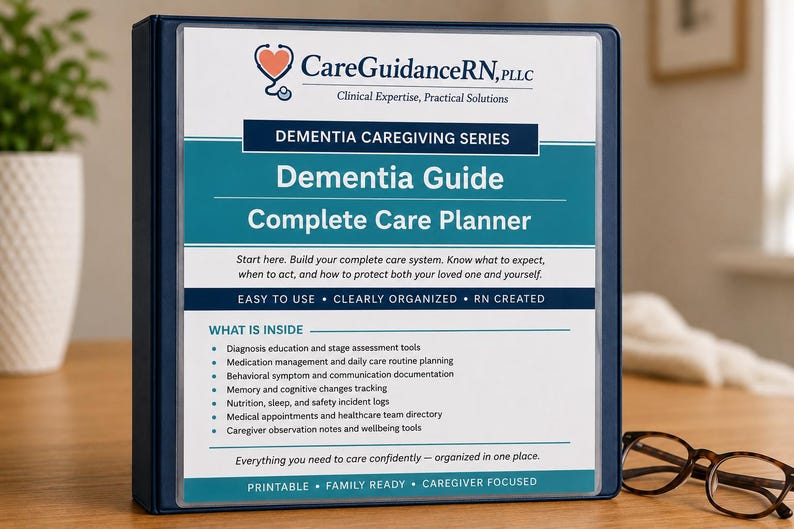 May include: A navy blue binder titled "Dementia Guide Complete Care Planner" with the CareGuidanceRN logo. The binder includes a list of contents and is designed for caregivers. A pair of eyeglasses rests on the wooden surface.