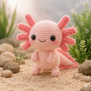 Peut inclure: Une peluche axolotl crochetée rose clair avec une tête ronde, deux grands yeux noirs en plastique, un petit sourire brodé et trois branchies externes plumeuses de chaque côté de la tête. Le corps et la queue sont en laine texturée.