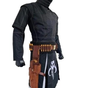 K&ouml;nnte beinhalten: Schwarzes Kost&uuml;m mit wei&szlig;en N&auml;hten, hohem Kragen und G&uuml;rtel mit goldenen Details. Eine braune Lederholster und ein schwarzer Rock mit wei&szlig;em Emblem sind ebenfalls zu sehen. Geeignet f&uuml;r Cosplay oder Themenveranstaltungen.