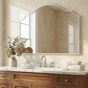 Peut inclure: Un meuble-lavabo de salle de bain avec un grand miroir cintr&eacute;. Le meuble est en bois fonc&eacute; et poss&egrave;de un comptoir en marbre. Un vase de fleurs et des serviettes blanches pli&eacute;es sont pos&eacute;s sur le comptoir. Le miroir a un cadre blanc.