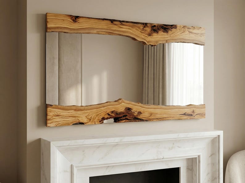 May include: A rectangular mirror with a natural wood frame. The frame has a raw, organic edge, showcasing the wood's grain and texture. The mirror is mounted above a white fireplace.