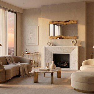 May include: An elegant living room featuring a curved beige sofa, a marble fireplace, and a large mirror with a wooden frame. A round coffee table and a chaise lounge add to the modern decor. The room is filled with warm, natural light.