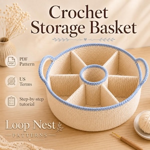 Op de afbeelding: Een ronde, crèmekleurige gehaakte opbergmand met lichtblauwe rand en twee handvatten. De mand heeft een centraal rond compartiment omringd door zes wigvormige secties. Tekst bevat Crochet Storage Basket, PDF Pattern, US Terms, Step-by-step tutorial en Loop Nest PATTERNS.