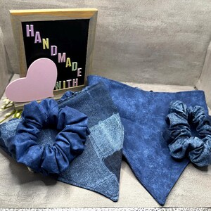 May include: A denim-themed set featuring two bandanas and two scrunchies. The bandanas are triangular, and the scrunchies are made of the same dark blue fabric. A framed sign reads "HANDMADE WITH" with a pink heart.