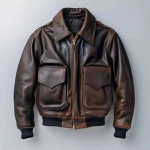 May include: A brown leather bomber jacket with a zip-up front, two front pockets, and a collared neckline. The jacket has black ribbed cuffs and a black ribbed hem. The leather has a distressed appearance.