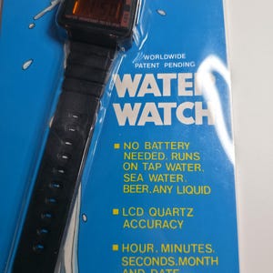 May include: A black digital Water Watch with a black band, displayed on a blue background. The watch face shows the time. Text on the packaging reads "Water Watch" and "No battery needed. Runs on tap water, sea water, beer, any liquid."