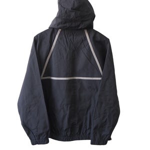 Op de afbeelding: Een marineblauwe jas met capuchon en een reflecterend wit driehoekontwerp op de rug. De jas heeft een volledige ritssluiting en elastische manchetten. De capuchon is bevestigd en de jas is gemaakt van lichtgewicht materiaal.