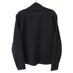 May include: A black long-sleeved shirt with a mock neck collar. The shirt is hanging on a metal hanger against a white background. The fabric appears to be a soft knit material.