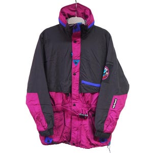 May include: A vintage black and magenta ski jacket with a high collar and a belt. The jacket features blue and white accents, a logo patch on the sleeve, and a drawstring at the bottom. This retro outerwear is suitable for cold weather.