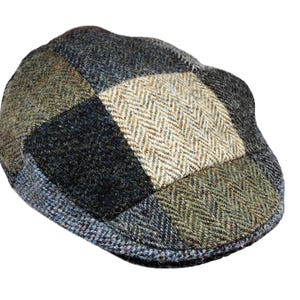 Może przedstawiać: Płaska czapka typu patchwork w odcieniach zieleni, błękitu i beżu. Czapka posiada wzór w jodełkę pośrodku i wykonana jest z teksturowanej tkaniny. Kapelusz w klasycznym stylu, odpowiedni na różne okazje.