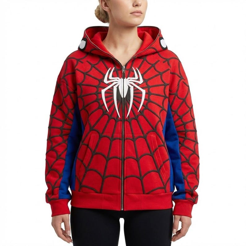 May include: Red zip-up hoodie featuring a black spiderweb design and a white spider emblem on the chest. The hoodie has blue side panels and white accents on the hood.