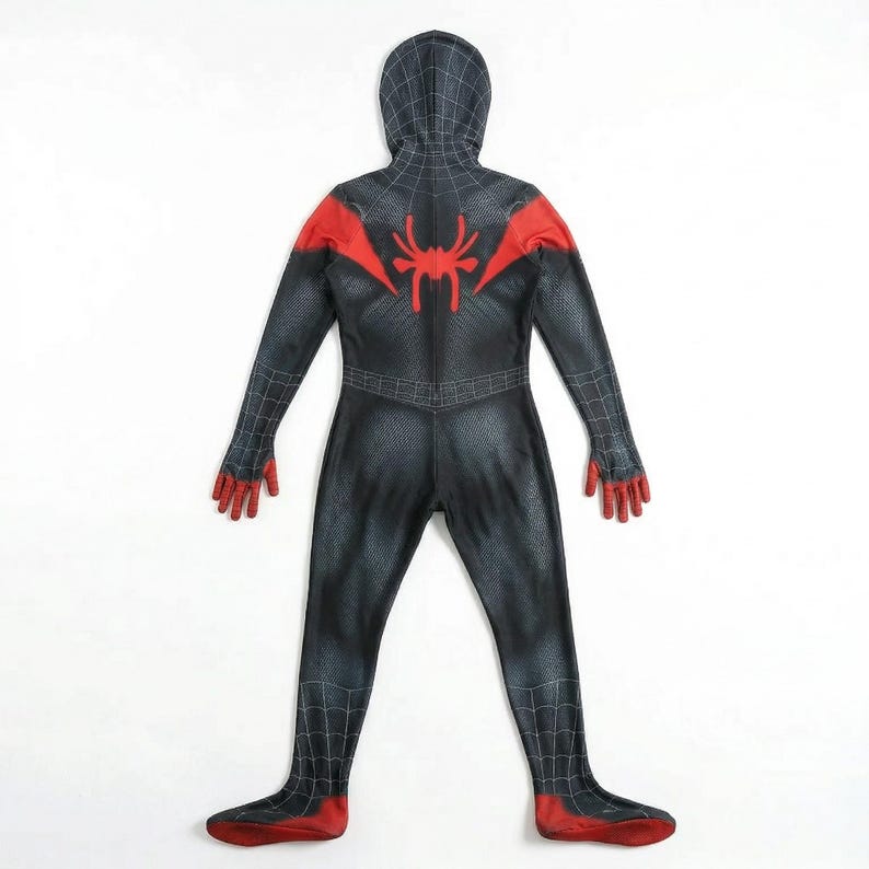 Puede incluir: Un disfraz de superh&eacute;roe negro y rojo con capucha. El disfraz presenta un emblema de ara&ntilde;a en la espalda y detalles rojos en los hombros, manos y pies. El traje tiene un patr&oacute;n texturizado.