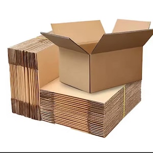 Peut inclure: Plusieurs boîtes en carton pliées et une boîte assemblée. Les boîtes sont de couleur marron clair et sont en carton ondulé. La boîte assemblée est ouverte, révélant l'intérieur. Un élastique jaune entoure la pile de boîtes pliées.