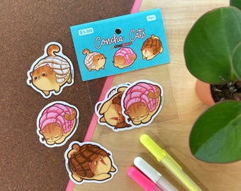 May include: A set of three Concha Cats stickers featuring cute cartoon cats shaped like Mexican sweet bread. The stickers are on a blue background with the text "Concha Cats" and "$5.00".