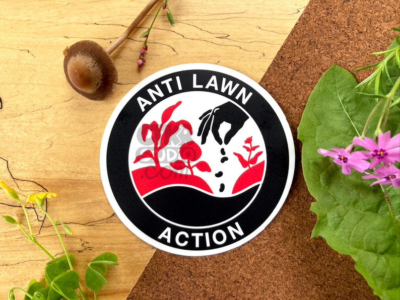 May include: A black and white round sticker with the words "Anti Lawn Action" in white lettering. The sticker features a red and white illustration of a hand planting seeds in the ground.