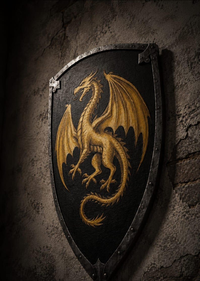 May include: A shield featuring a gold dragon on a black background. The dragon is depicted with outstretched wings. The shield has a metal border and is mounted on a textured, grey wall. The shield is a decorative item.
