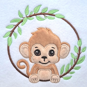 May include: Embroidered design of a smiling brown monkey inside a circular frame of brown branches and green leaves. The monkey has large brown eyes and is sitting upright. The background is white.