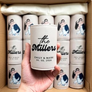 May include: A light beige foam can cooler featuring a black graphic of a couple embracing. The text reads The Millers, EMILY & MARK, and 30. 05. 2026. The cooler is cylindrical with a flat top and bottom, designed to insulate a standard beverage can.