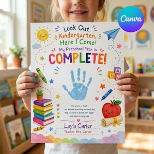 May include: A colorful kindergarten graduation print held by a child. The print features the text "Look Out Kindergarten, Here I Come! My Preschool Year is COMPLETE!" along with a blue handprint, a smiling sun, and other illustrations.