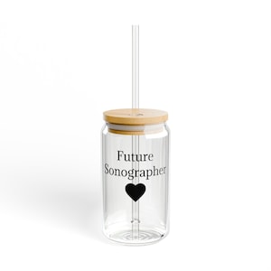 Puede incluir: Un vaso de vidrio transparente con tapa de bambú y pajita transparente. El vaso tiene las palabras "Future Sonographer" y un corazón negro impreso en el frente.