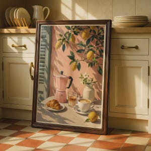 Könnte beinhalten: Ein gerahmter Kunstdruck, der ein Stillleben mit einer rosa Mokkakanne, einer weißen Kaffeetasse, einem Glas Eiskaffee, einem Croissant auf einem Teller und einer Zitrone auf einem Tisch vor einer rosa Wand mit Zitronenzweigen und Blättern zeigt.