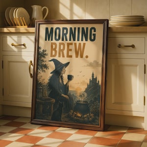 May include: A framed wall art print featuring the text MORNING BREW. The illustration depicts a witch in a pointed hat holding a mug, sitting beside a black cat and a steaming cauldron near a castle at sunrise. The frame is dark brown wood.