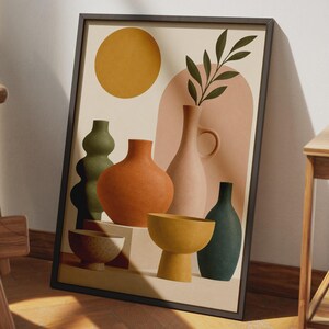 May include: A framed wall art print featuring a collection of vases and bowls in various shapes and colors including olive green, burnt orange, soft pink, and mustard yellow, set against a cream background with a large yellow circle and arch.