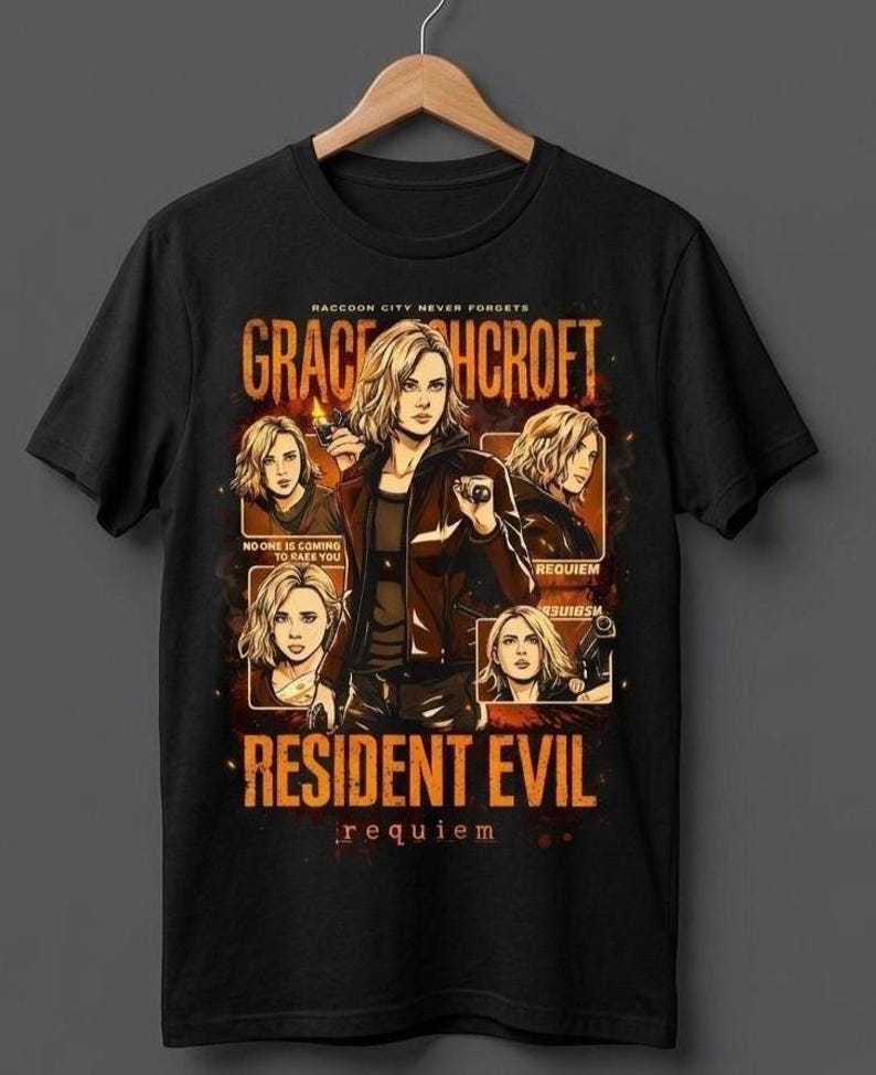 May include: Black t-shirt featuring a graphic of a woman with blonde hair, holding a gun, with the text "GRACE CROFT" and "RESIDENT EVIL requiem". The design includes multiple images of the woman and the phrase "RACCOON CITY NEVER FORGETS".