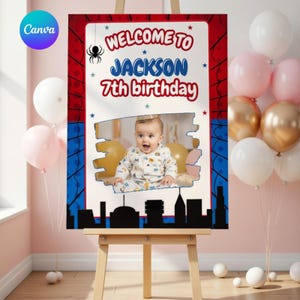 Op de afbeelding: Een verjaardag welkom bord met een foto van een baby, de tekst "WELCOME TO JACKSON 7th birthday", en een silhouet van een stadsgezicht. Het bord staat op een ezel, met ballonnen op de achtergrond.