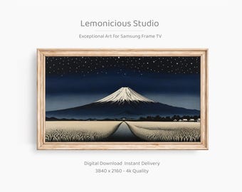 Könnte beinhalten: Ein gerahmter Druck eines japanischen Landschaftsbildes mit dem Fuji unter einem Sternenhimmel. Das Kunstwerk zeigt einen dunkelblauen Himmel, einen schneebedeckten Berg und ein Feld im Vordergrund. Der Rahmen ist hellbraun. Der Text auf dem Bild lautet "Lemonicious Studio".