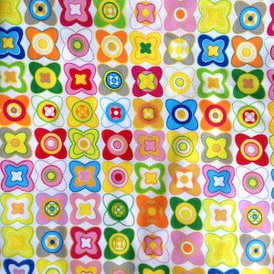 Peut inclure: Un motif de tissu présentant une grille répétitive de formes de fleurs stylisées à quatre pétales et de motifs circulaires dans des couleurs vives, notamment jaune, orange, rose, vert, bleu et gris sur un fond blanc, créant un design géométrique dense.