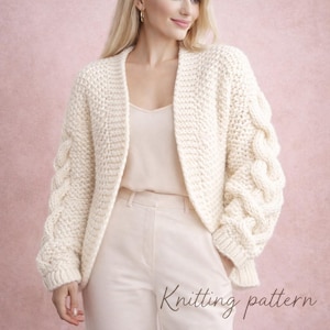 May include: Cream-colored, chunky knit cardigan with cable knit sleeves. The open-front sweater has a textured stitch pattern and is shown with the text "Knitting pattern" at the bottom. The cardigan is worn over a light-colored top and pants.