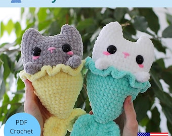 May include: Two crocheted mermaid cat plushies. One is gray with a yellow tail, the other is white with a teal tail. Both have black eyes and pink cheeks. The text "Kitty the Mermaid" is at the top, and "PDF Crochet Pattern" is in a circle at the bottom.